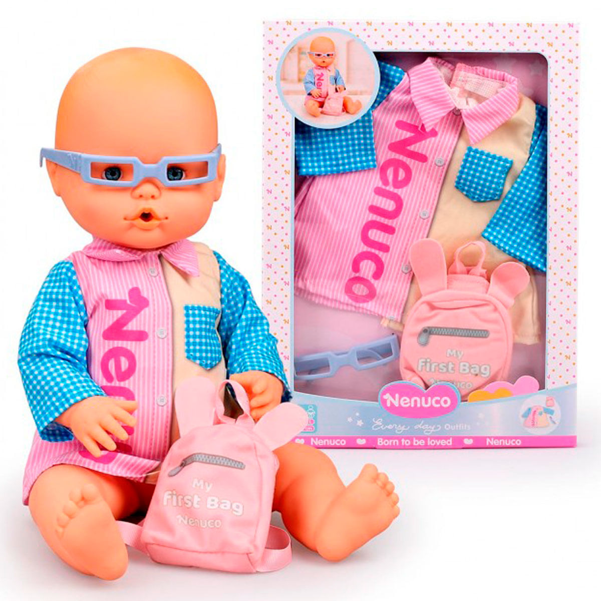 Una muñeca con gafas y una mochila rosa. Lleva una camisa y está sentada junto a una caja con ropa de muñeca.