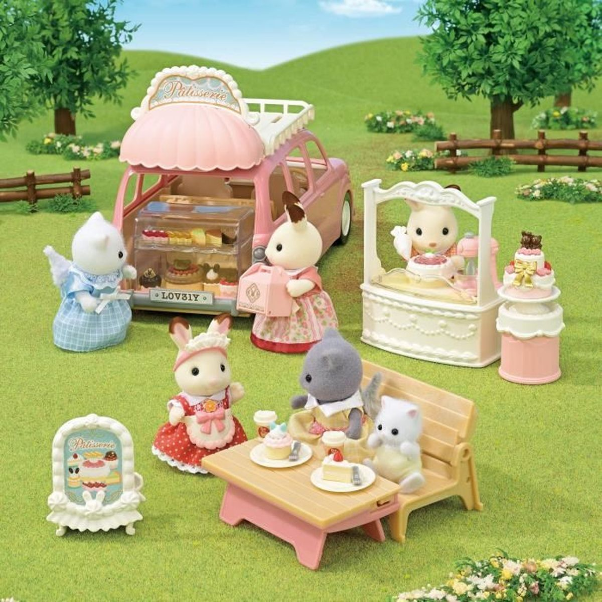Una escena de panadería de juguete con figuras de animales. Una furgoneta rosa, una mesa con golosinas y figuras vendiendo y comiendo pastel, en un campo verde.