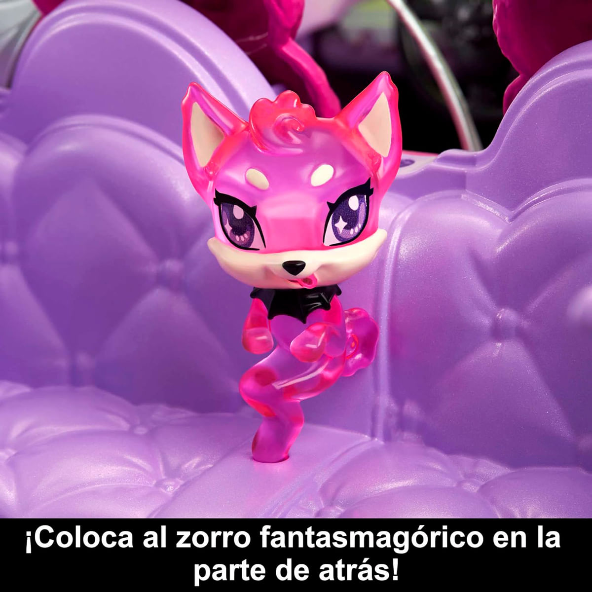 Ein rosa Fuchspielzeug mit schwarzem Kragen steht auf einem lila Sofa. Der Fuchs hat große Augen und einen verspielten Ausdruck.