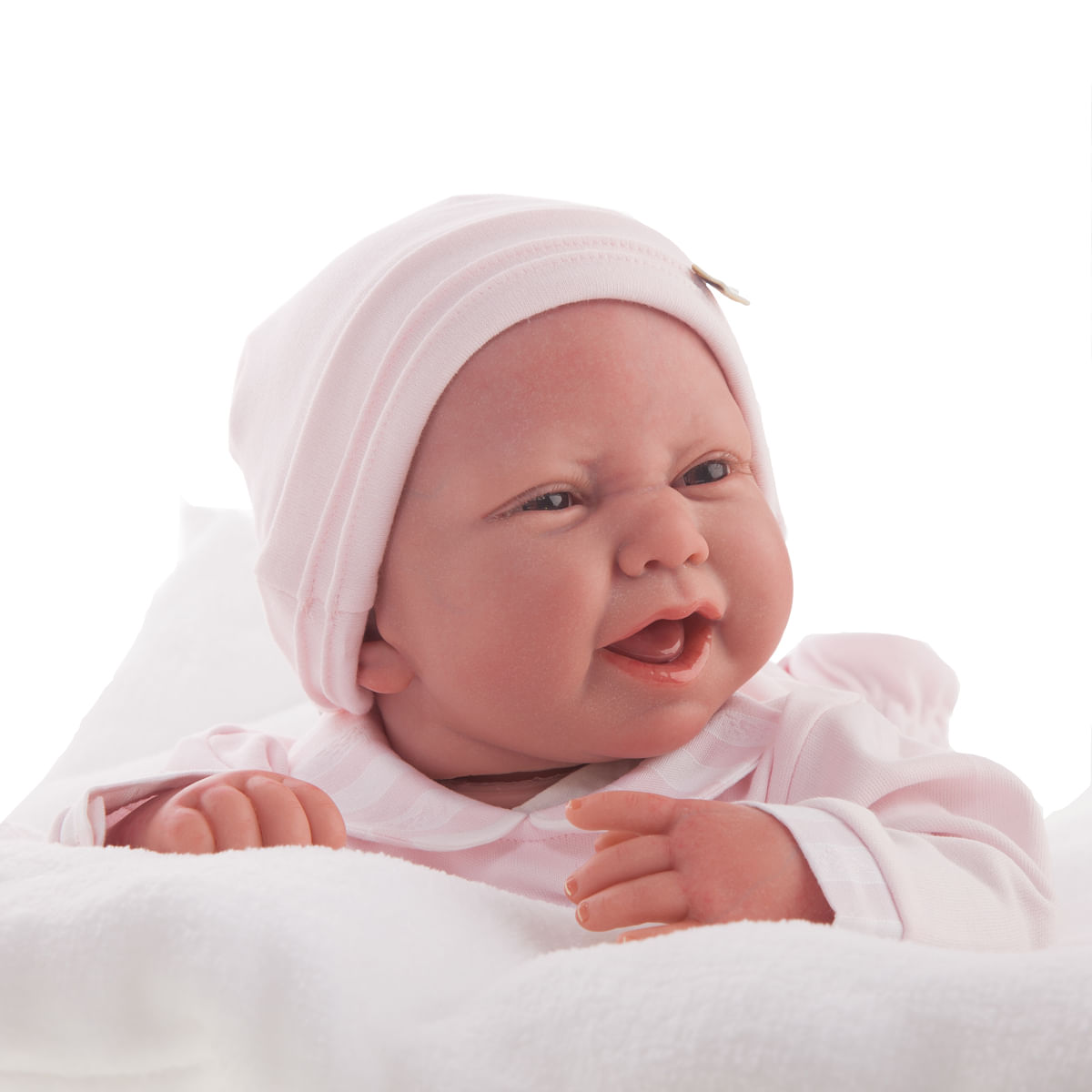 Un muñeco de bebé con gorro y traje rosa, con la boca abierta. Descansa sobre una manta blanca sobre un fondo blanco.