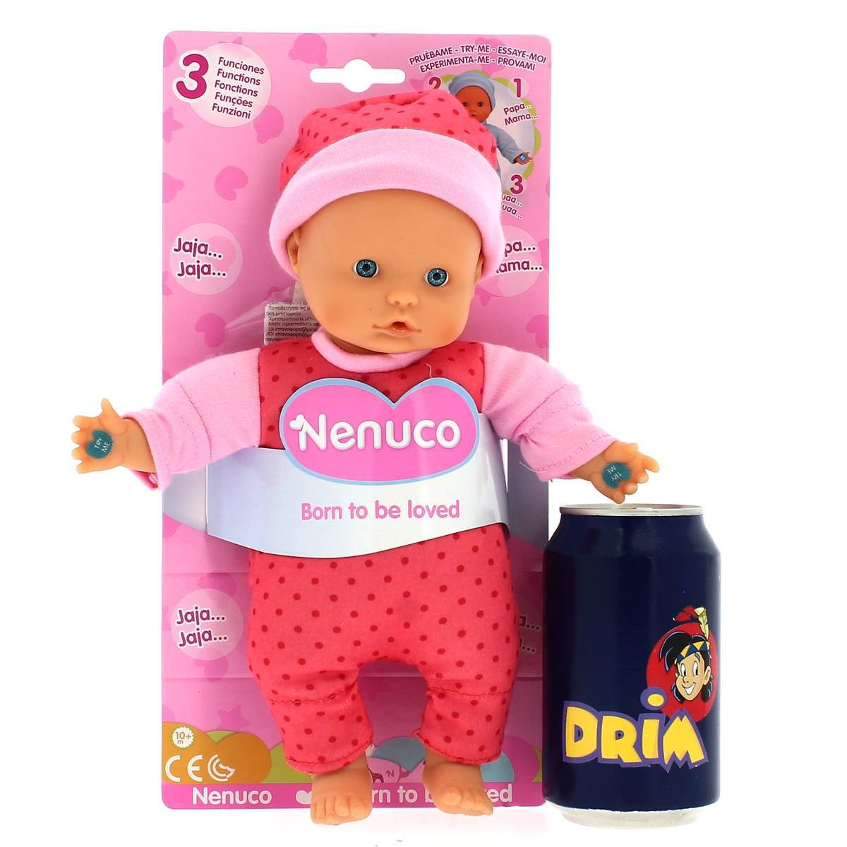 Una muñeca bebé con un conjunto rosa, una lata azul de refresco DRIM, sobre una caja rosa con la palabra Nenuco.