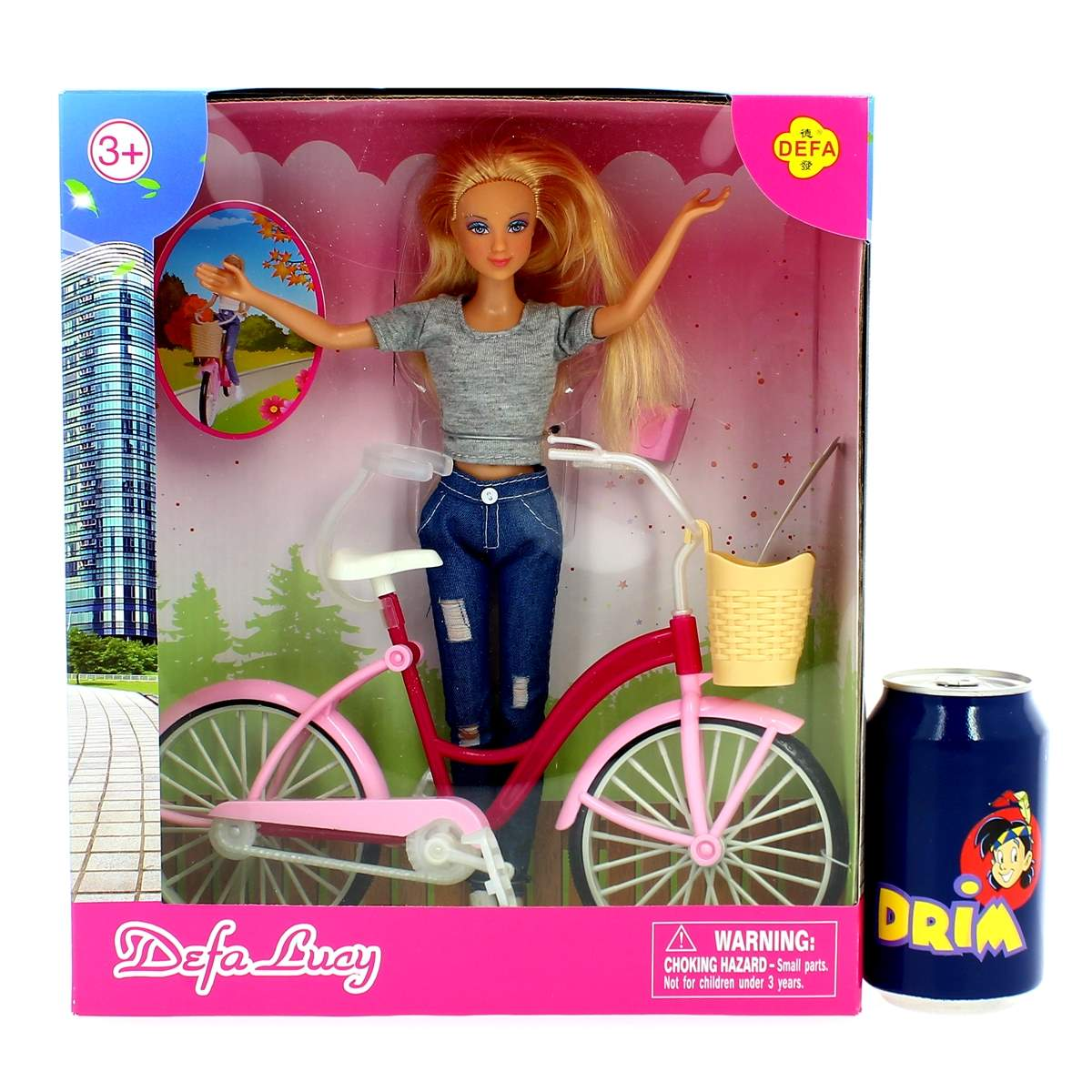 Una muñeca en una bicicleta rosa está dentro de una caja. Una lata azul con una caricatura está a la derecha. La caja tiene una etiqueta de advertencia.