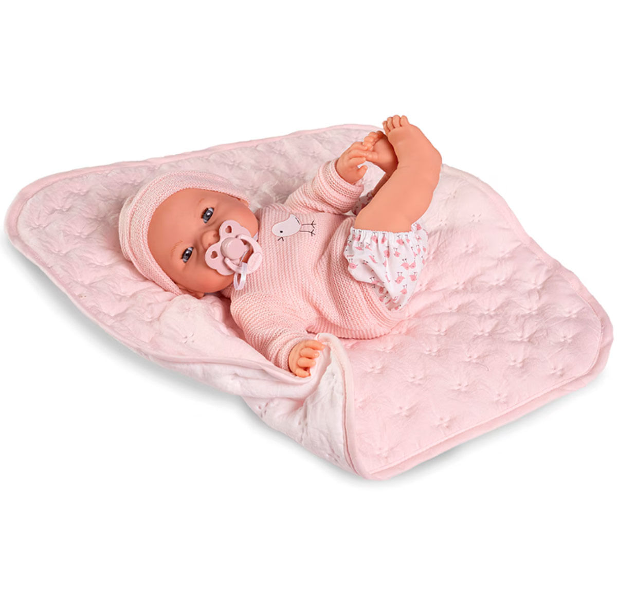 Una muñeca bebé con ropa y gorro rosa, con chupete, yace sobre una manta rosa.