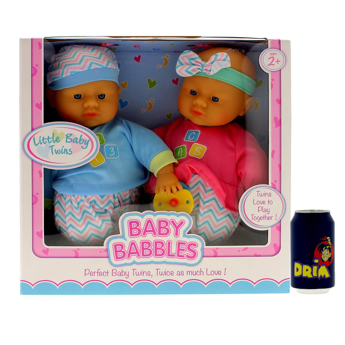 Una caja con dos muñecas bebés con sombreros y ropa. Un bote de DRIA está a la derecha. La caja dice 'Baby Babbles'.