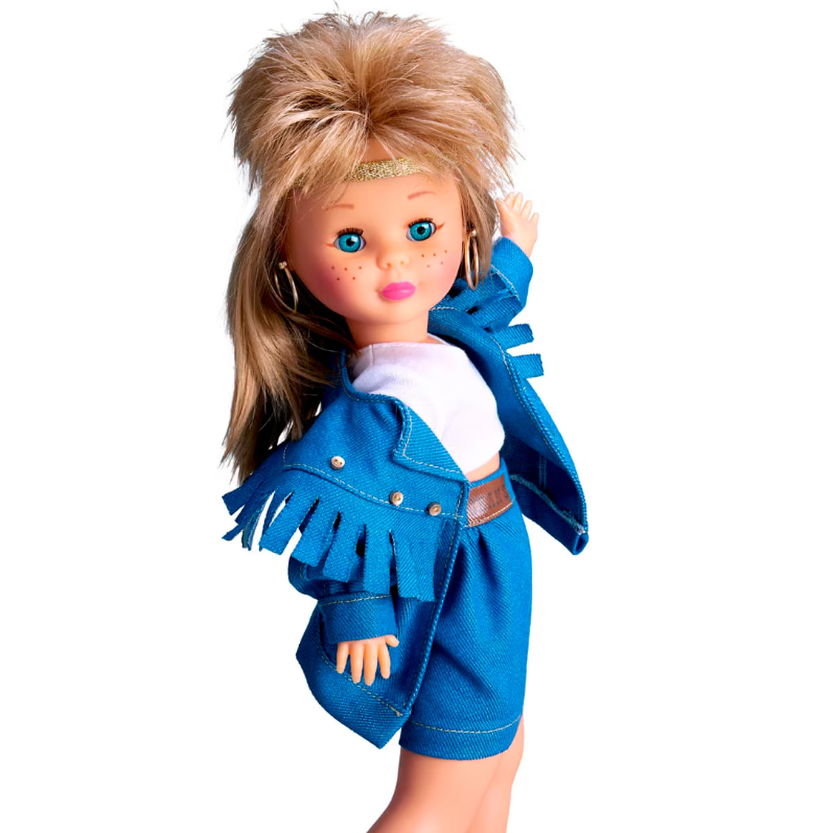 Una muñeca con cabello rubio, ojos azules y pecas, vestida con chaqueta vaquera azul, pantalones cortos y top blanco, con aros dorados.
