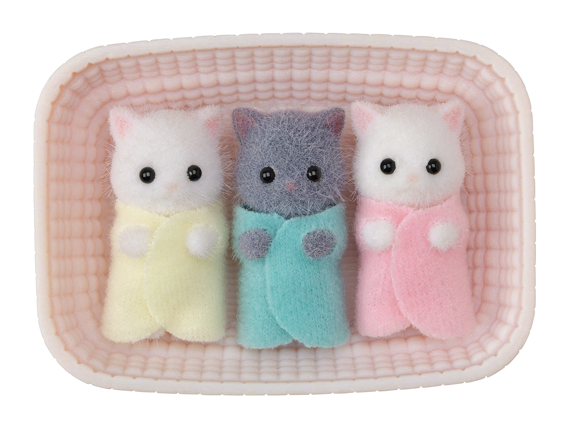 Tres gatitos de juguete en una cesta. Uno gris, dos blancos. Cada uno envuelto en una manta: amarilla, turquesa y rosa.