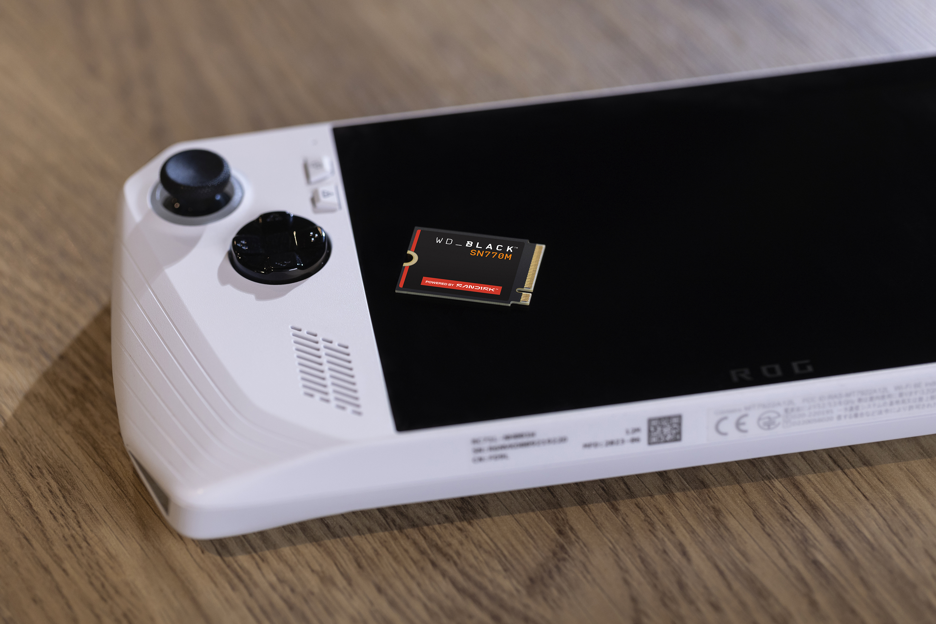 Białe urządzenie do gier przenośnych z czarnym ekranem i dyskiem WD_BLACK SN770M.