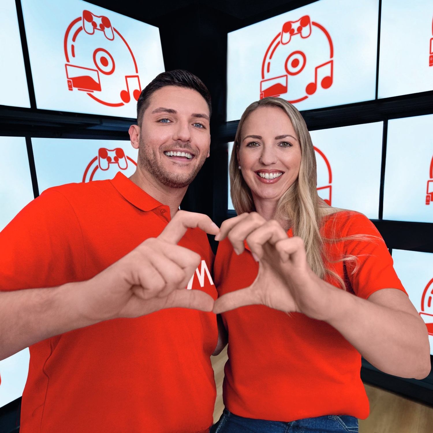 Un uomo e una donna con magliette rosse fanno un cuore con le mani. Loghi a tema gaming sullo sfondo.
