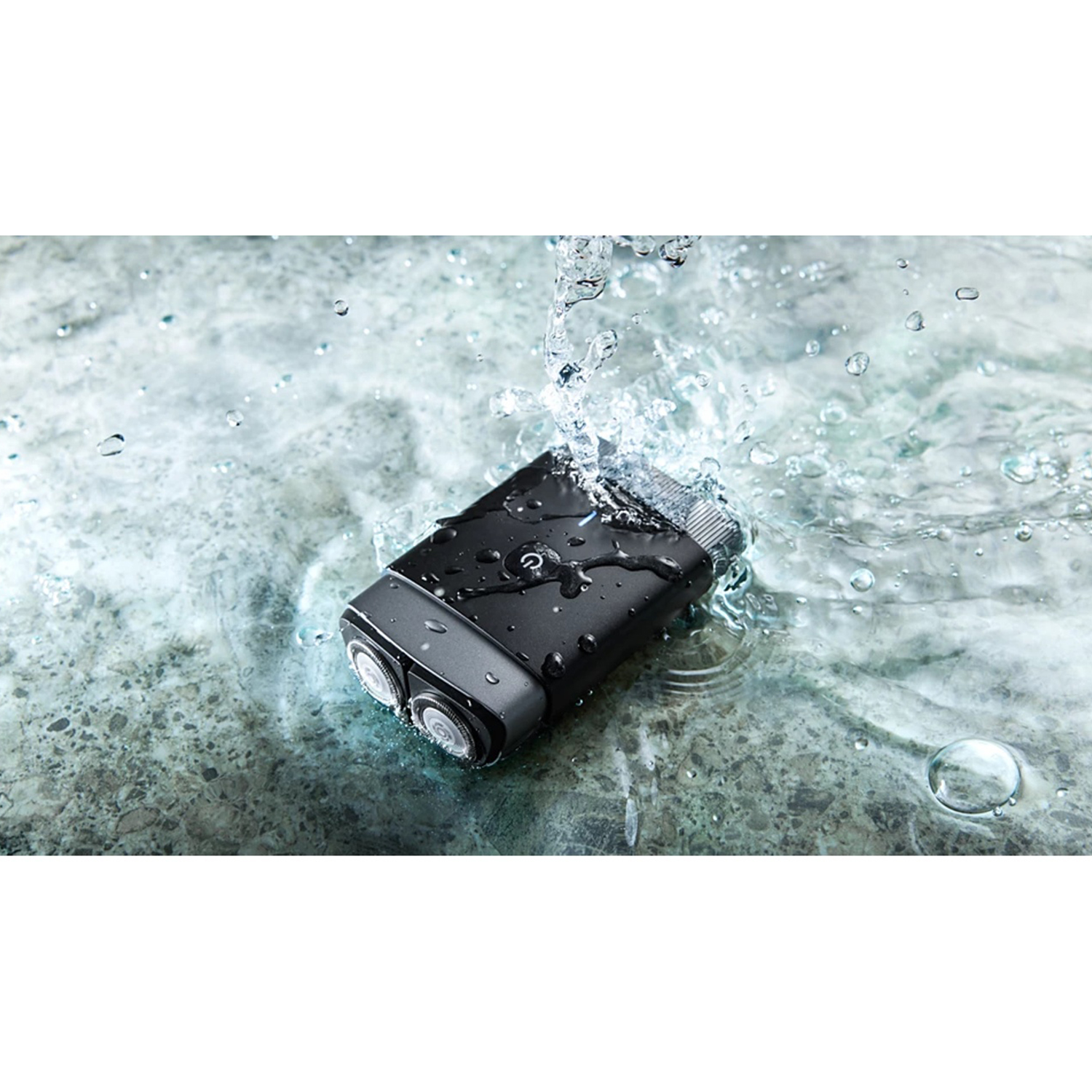 Czarna golarka elektryczna zanurzona w wodzie, z rozpryskami i kroplami. Golarka ma dwie głowice.