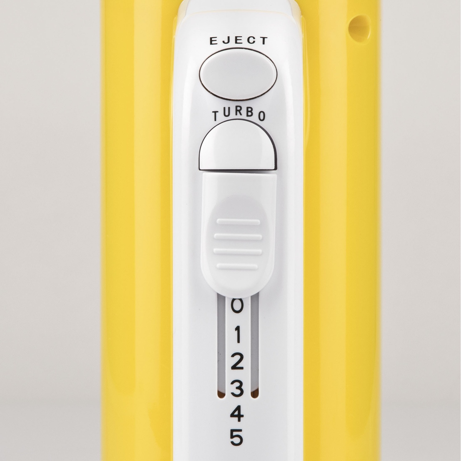 Primo piano di un frullatore a mano giallo e bianco. Ha pulsanti per espellere e turbo, oltre a un'impostazione della velocità da 0 a 5.