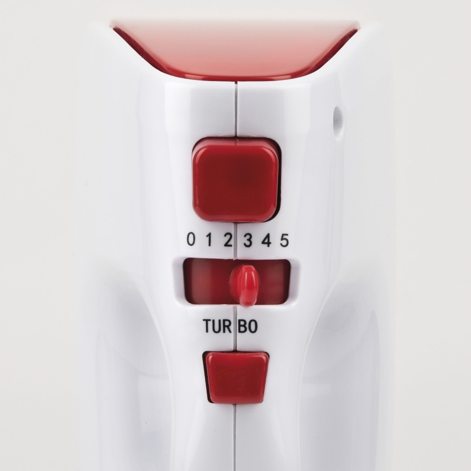 Primo piano di un frullatore a mano bianco e rosso. Ha un quadrante di velocità con i numeri 0-5, un pulsante turbo e un coperchio rosso.