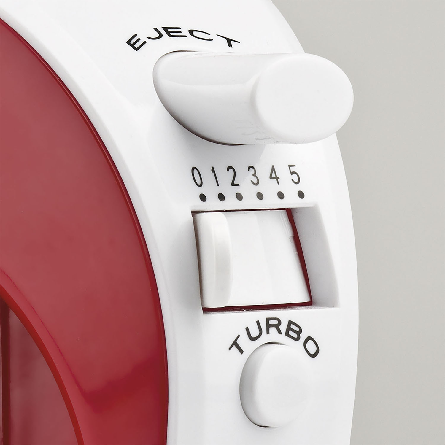 Primer plano del panel de control de una batidora blanca y roja. Tiene ajustes de velocidad, un botón turbo y un botón de expulsión. Números 0-5 visibles.