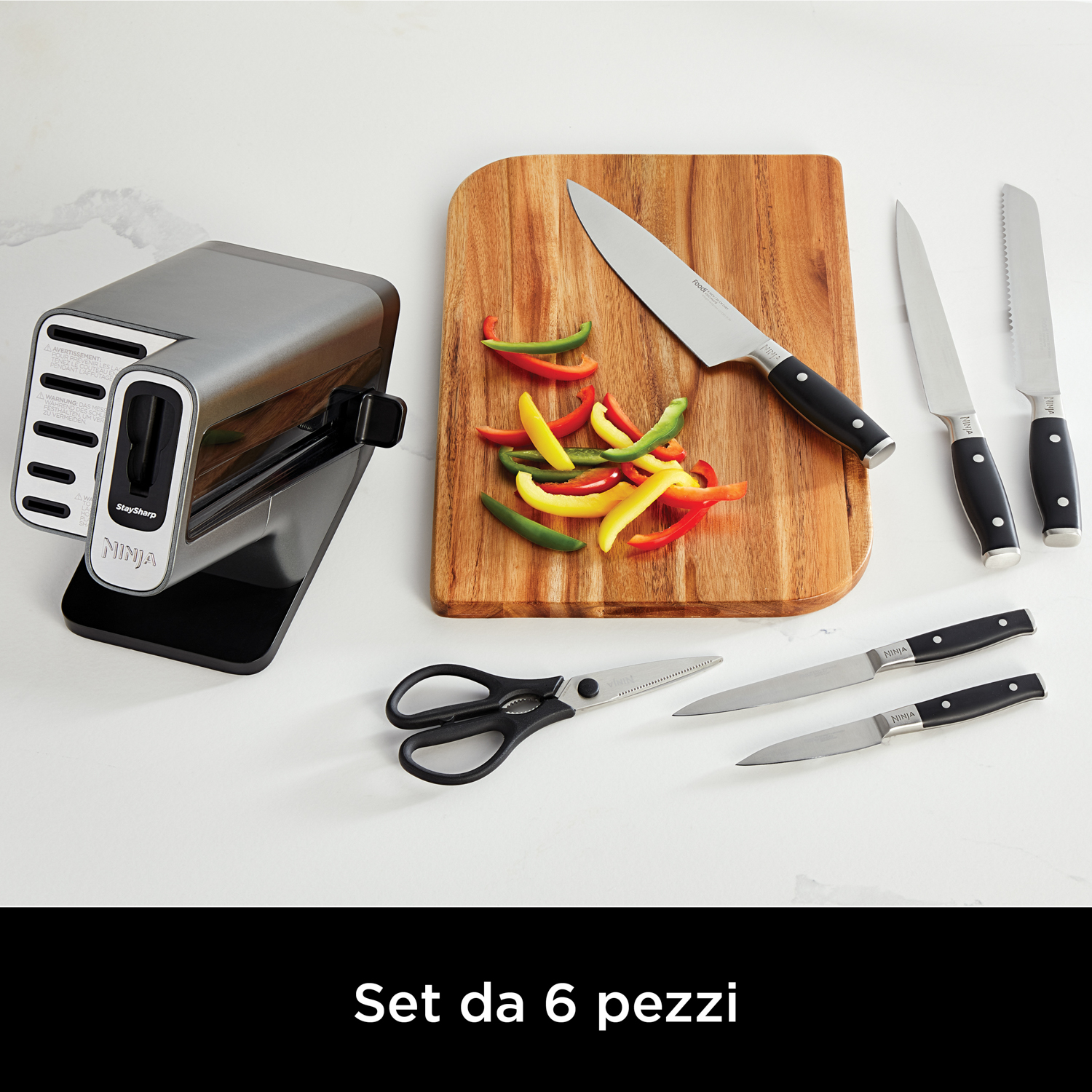 Un juego de cuchillos de cocina con afilador, tabla, cuchillos, tijeras y pimientos.