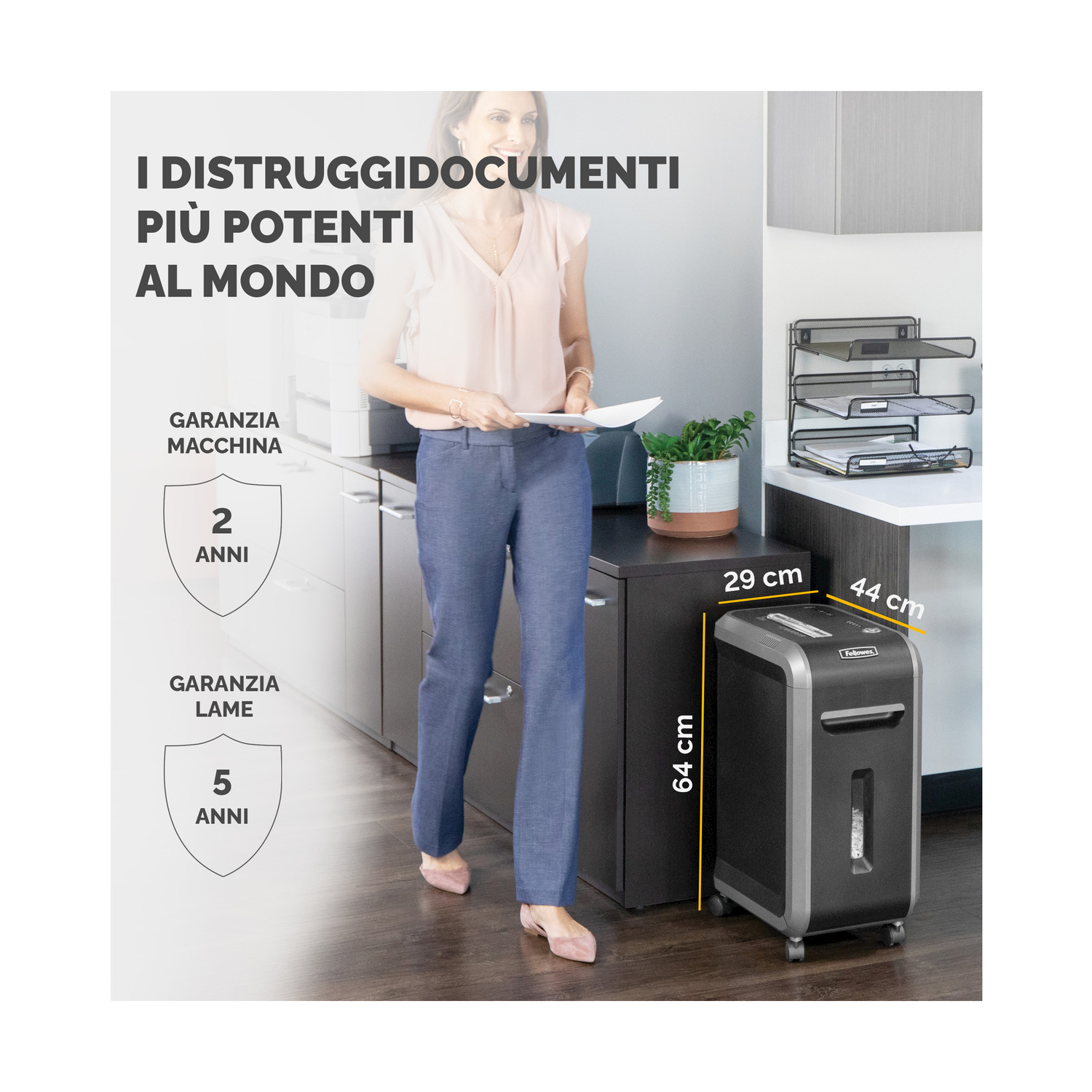 Kobieta stoi obok niszczarki do papieru. Tekst mówi, że jest najpotężniejsza na świecie. Wymiary: 29 cm, 44 cm i 64 cm.