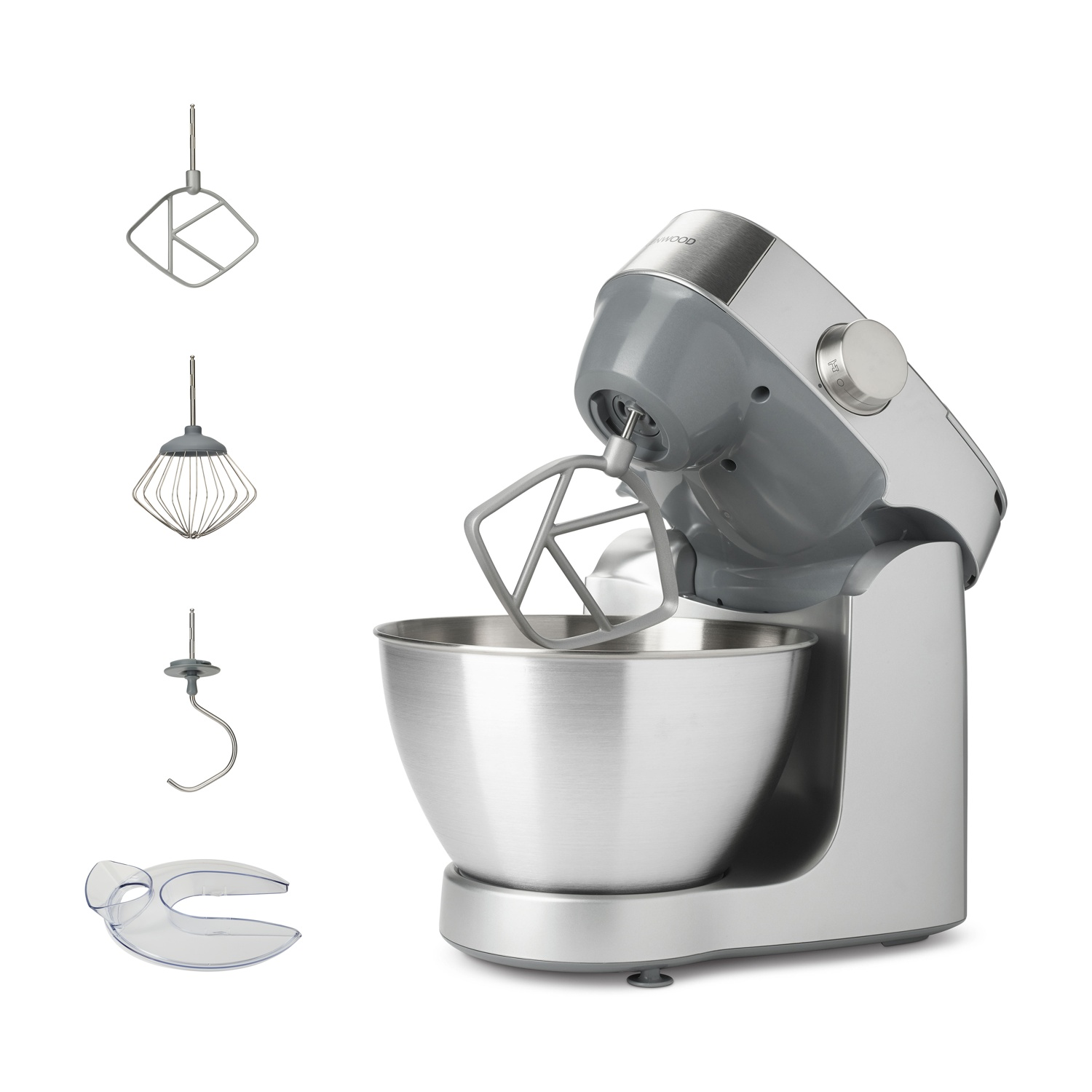 Gümüş renkli bir Kenwood mikser, çırpıcı, hamur kancası, çırpma teli ve sıçrama koruyucusu aksesuarlarıyla. Beyaz bir arka plan üzerinde.