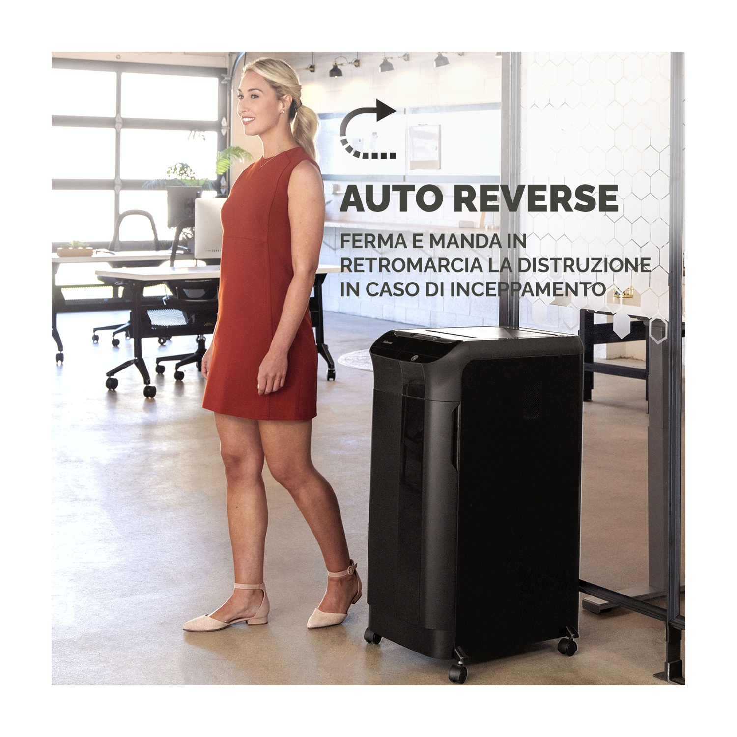 Una mujer con un vestido rojo está de pie cerca de una destructora negra. La escena incluye muebles de oficina y el texto 'AUTO REVERSE'.