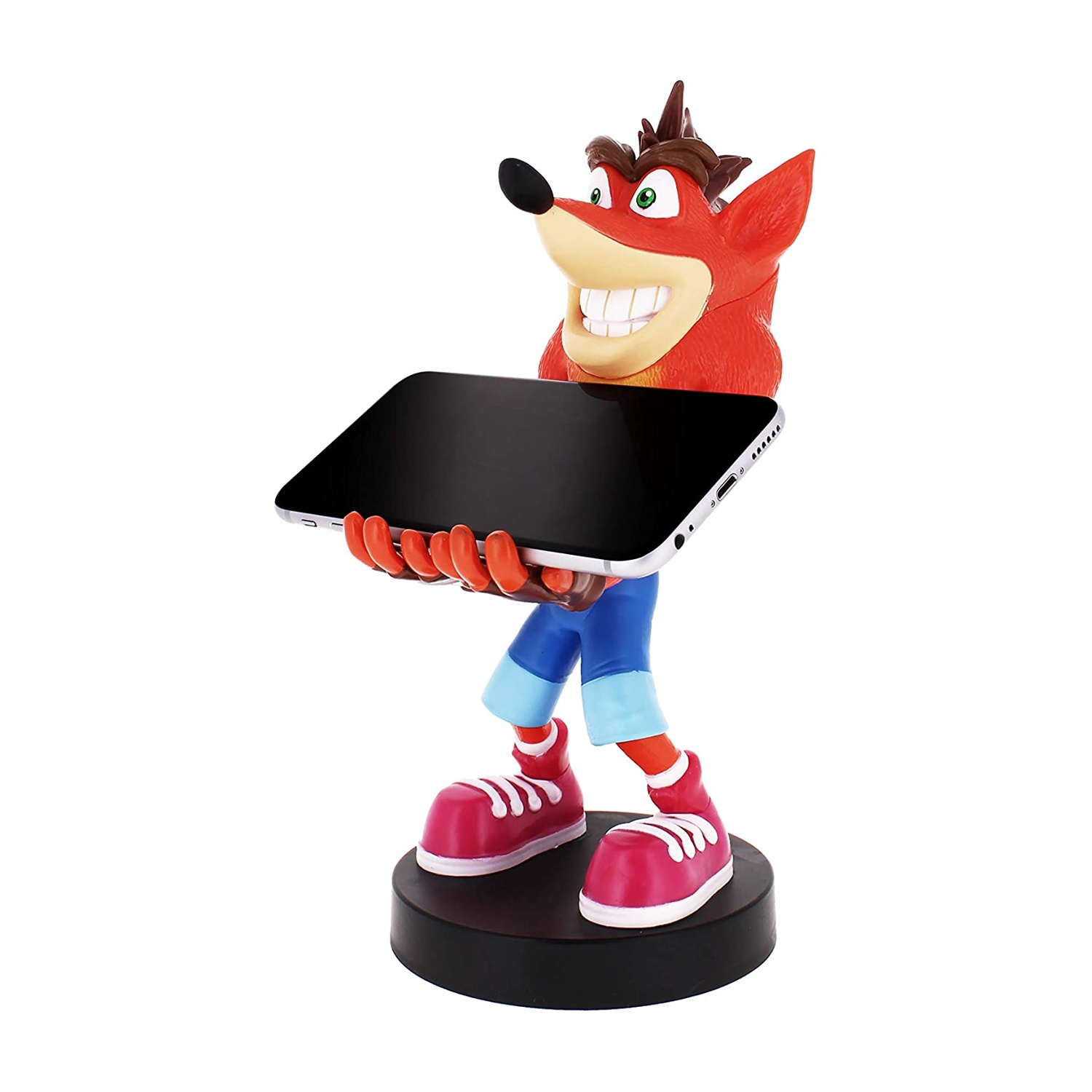 Una statuetta di Crash Bandicoot che tiene un telefono. Ha pelliccia arancione, pantaloni blu e scarpe rosse, in piedi su una base nera.