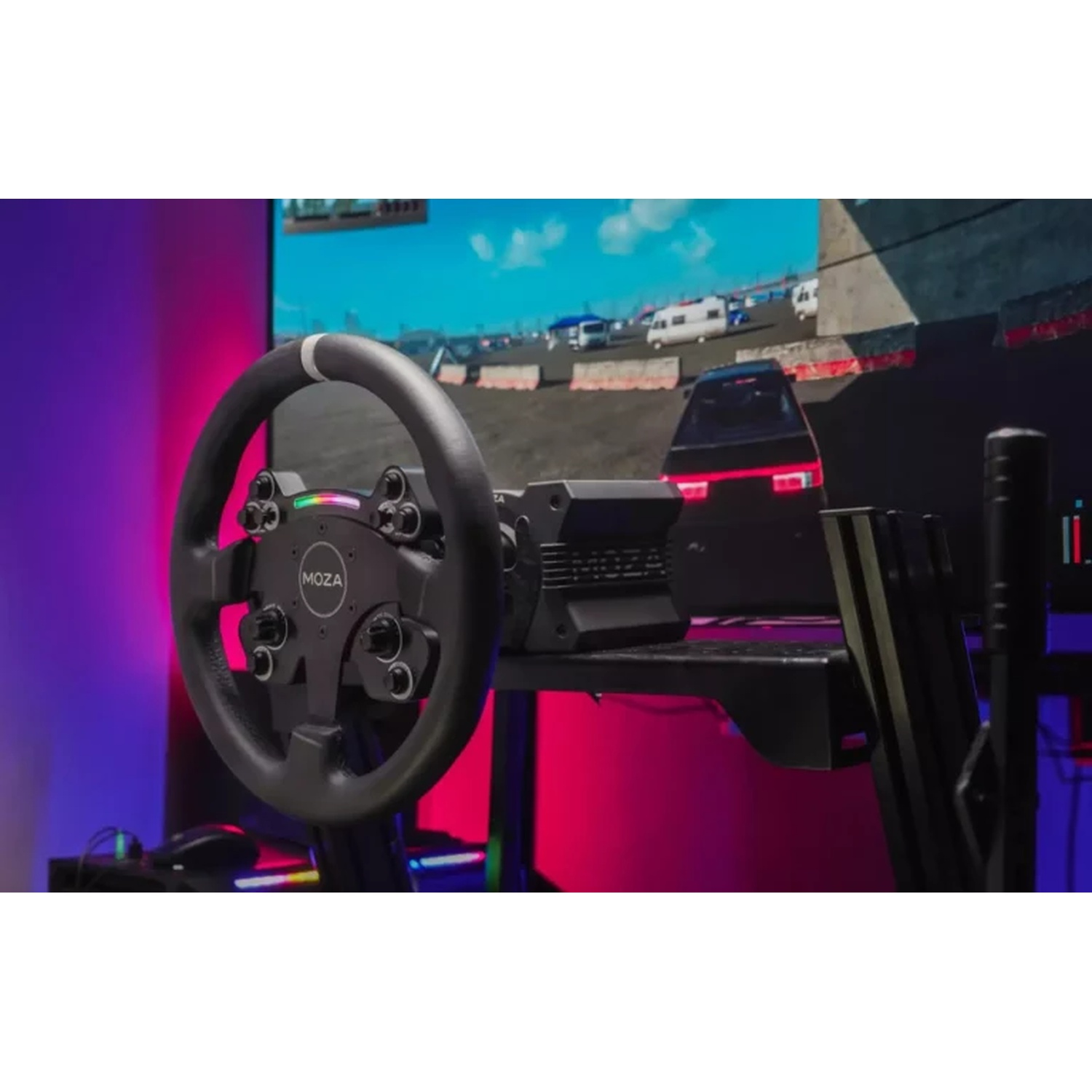 Une configuration de simulateur de course. Un volant MOZA noir est au premier plan, avec un écran montrant une course en arrière-plan.