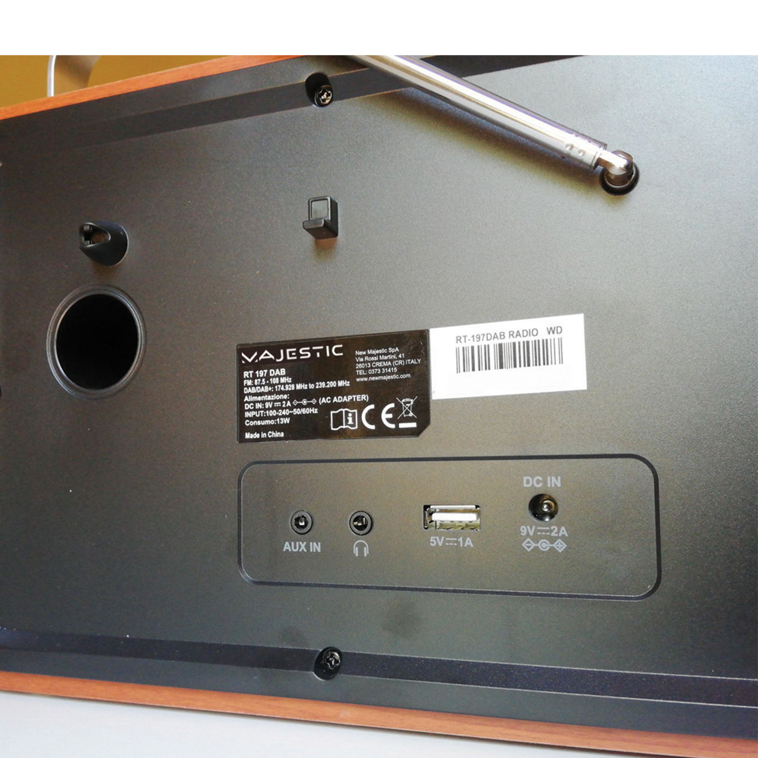 Rückseite eines Majestic RT 197 DAB Radios. Enthält Anschlüsse, Etiketten und Antenne. Braune Holzverkleidung unten.