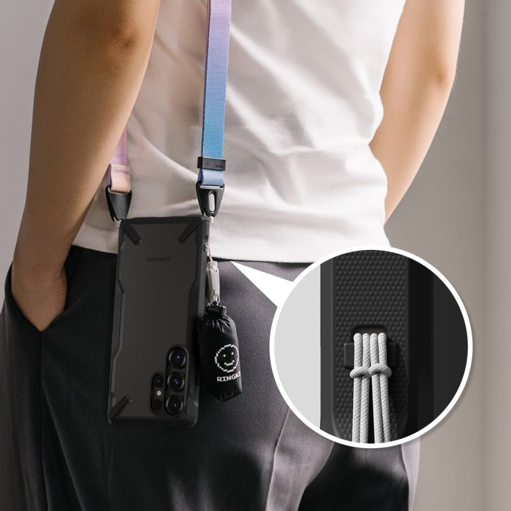 Una persona indossa un telefono con un cinturino. Il telefono è in una custodia e ha una piccola borsa attaccata. Il cinturino è colorato.