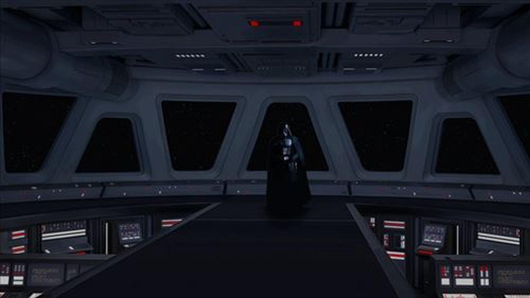 Darth Vader è in piedi in un interno scuro di una nave spaziale. Grandi finestre mostrano lo spazio. La scena è illuminata da luci blu e rosse.