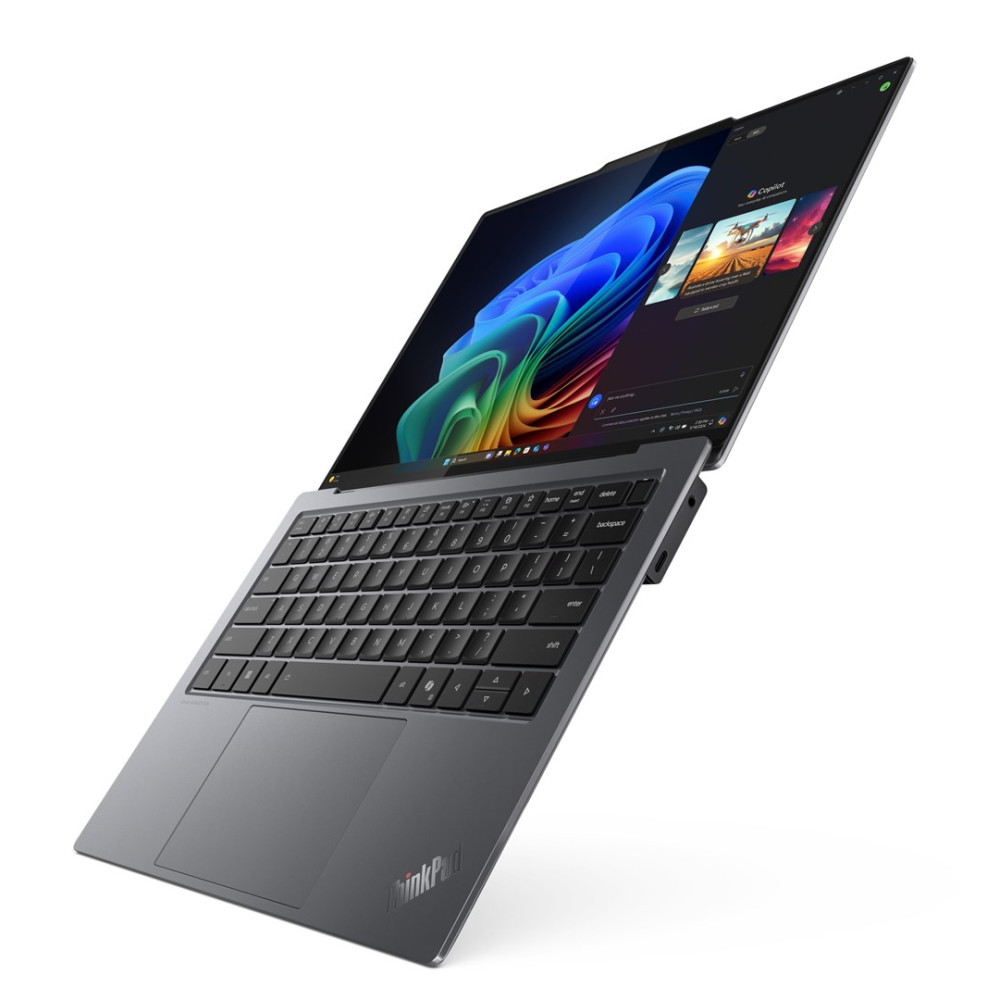 Szary laptop ThinkPad jest otwarty pod kątem. Ekran wyświetla kolorowy obraz abstrakcyjny i kilka miniatur. Klawiatura jest czarna.