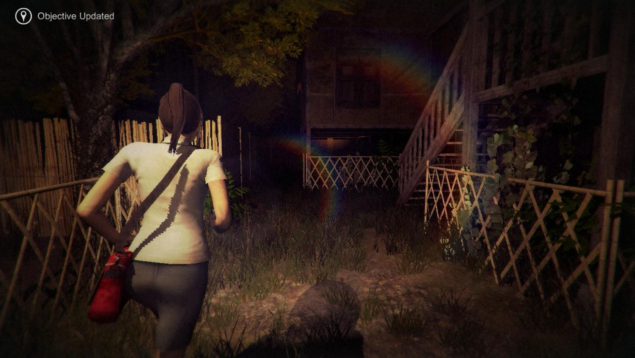 Una donna cammina verso una casa di notte. Una borsa rossa le pende dalla spalla. È visibile un effetto simile all'arcobaleno.