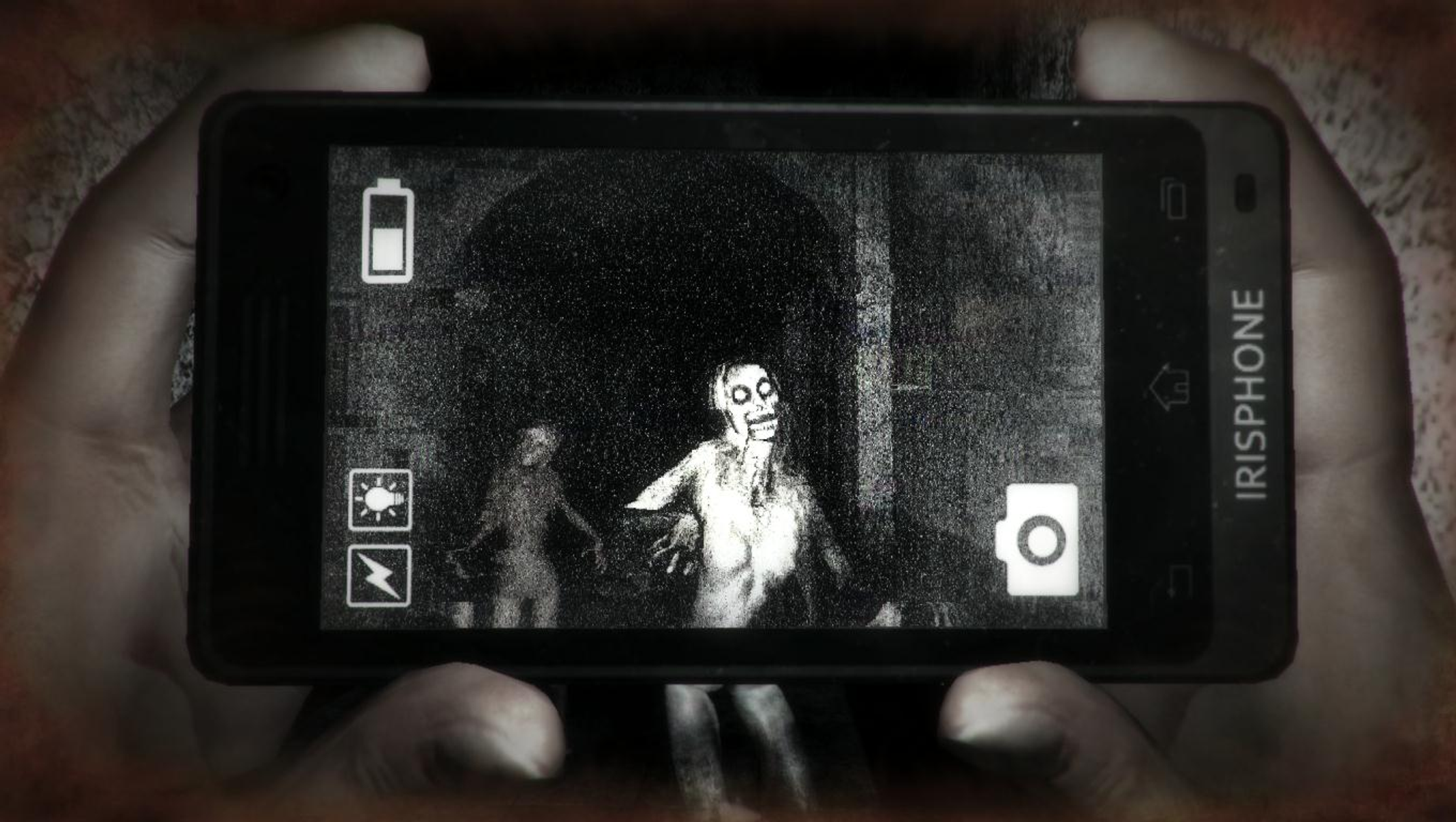 Un telefono mostra un'immagine spaventosa di due zombi in un corridoio buio. Il telefono è tenuto da due mani.