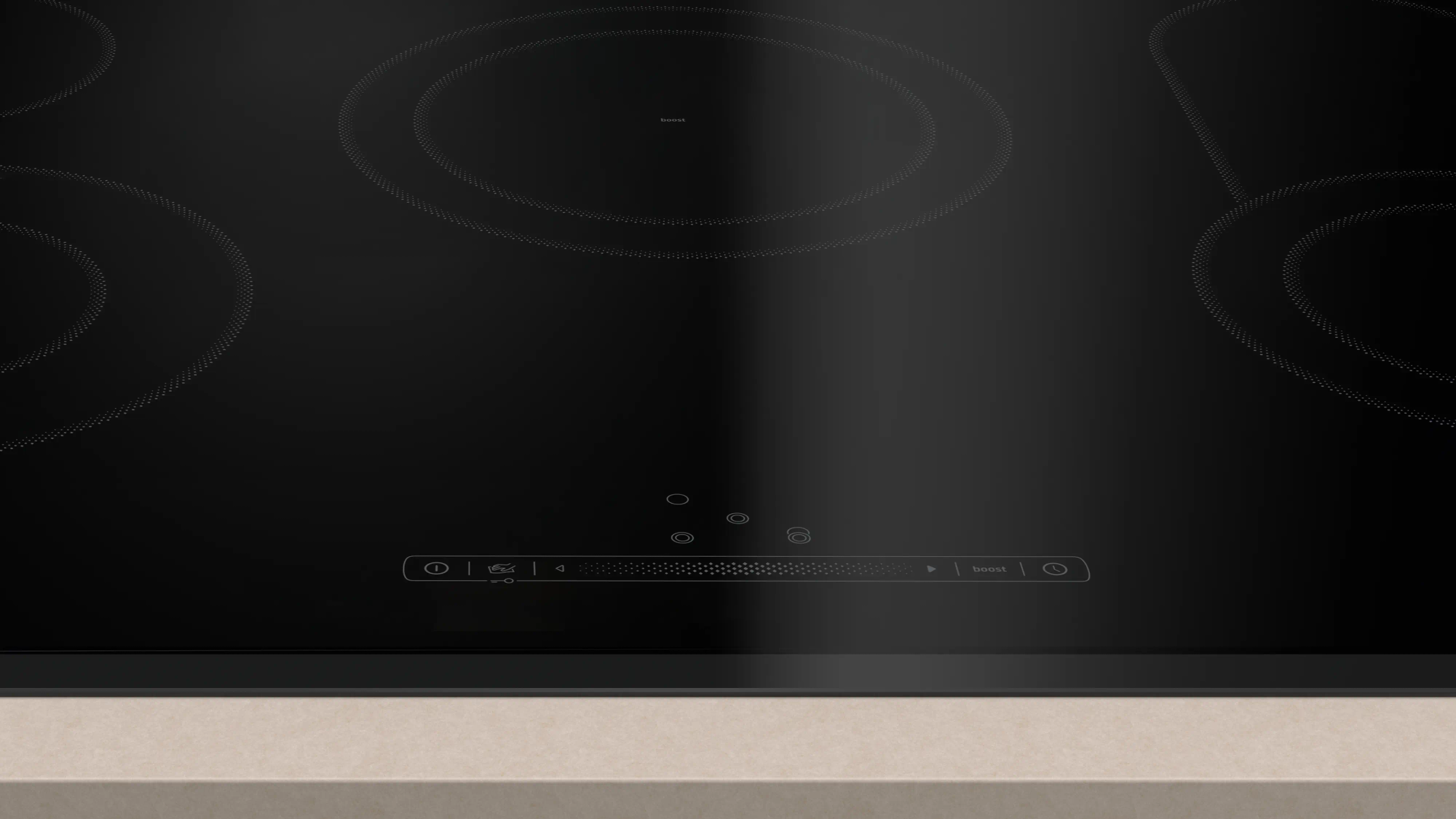 Primer plano de una placa de inducción negra. Tiene cuatro zonas de cocción. El panel de control está abajo con controles táctiles.