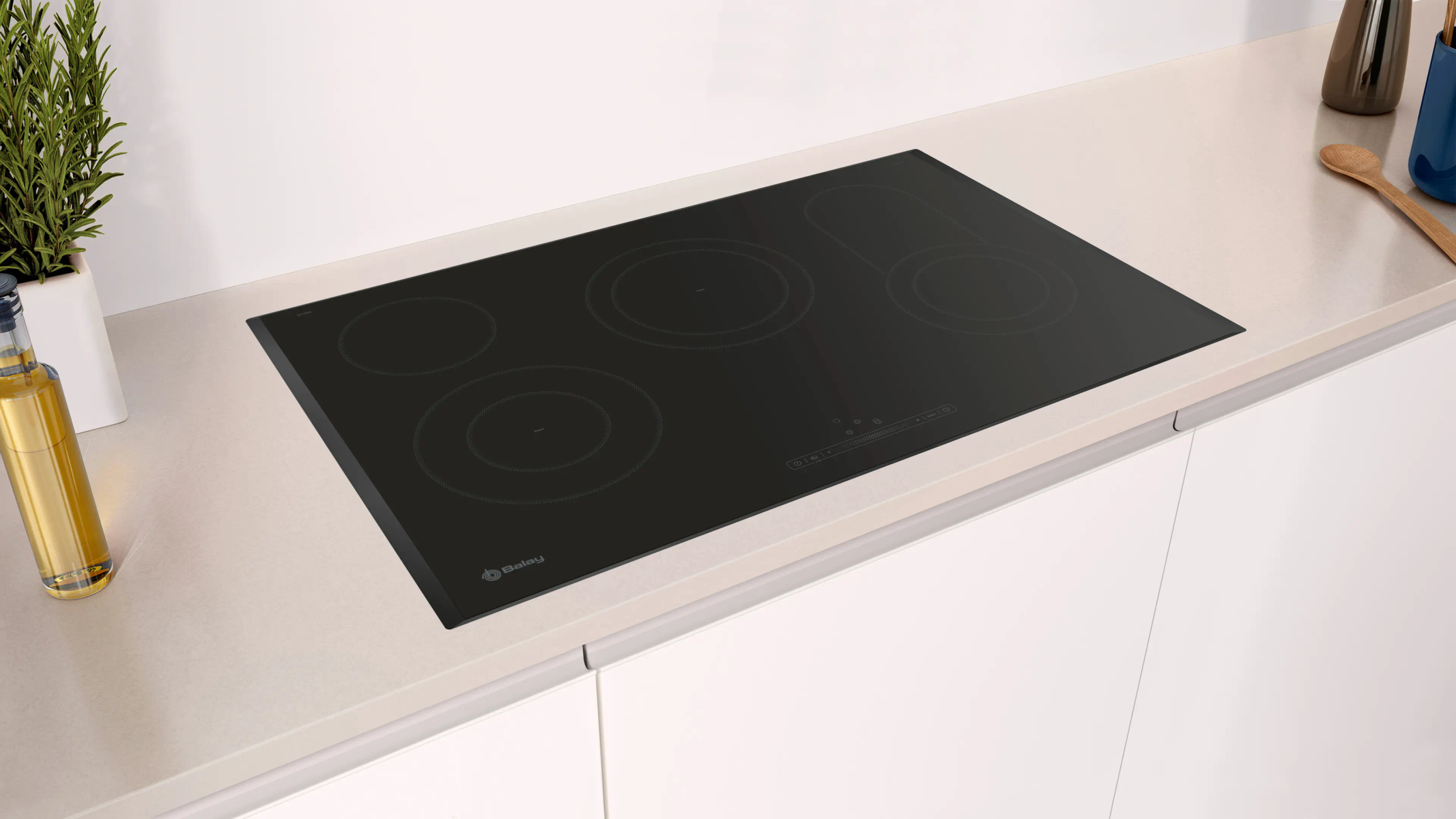 Placa de inducción negra Balay sobre encimera de cocina con utensilios y una planta.