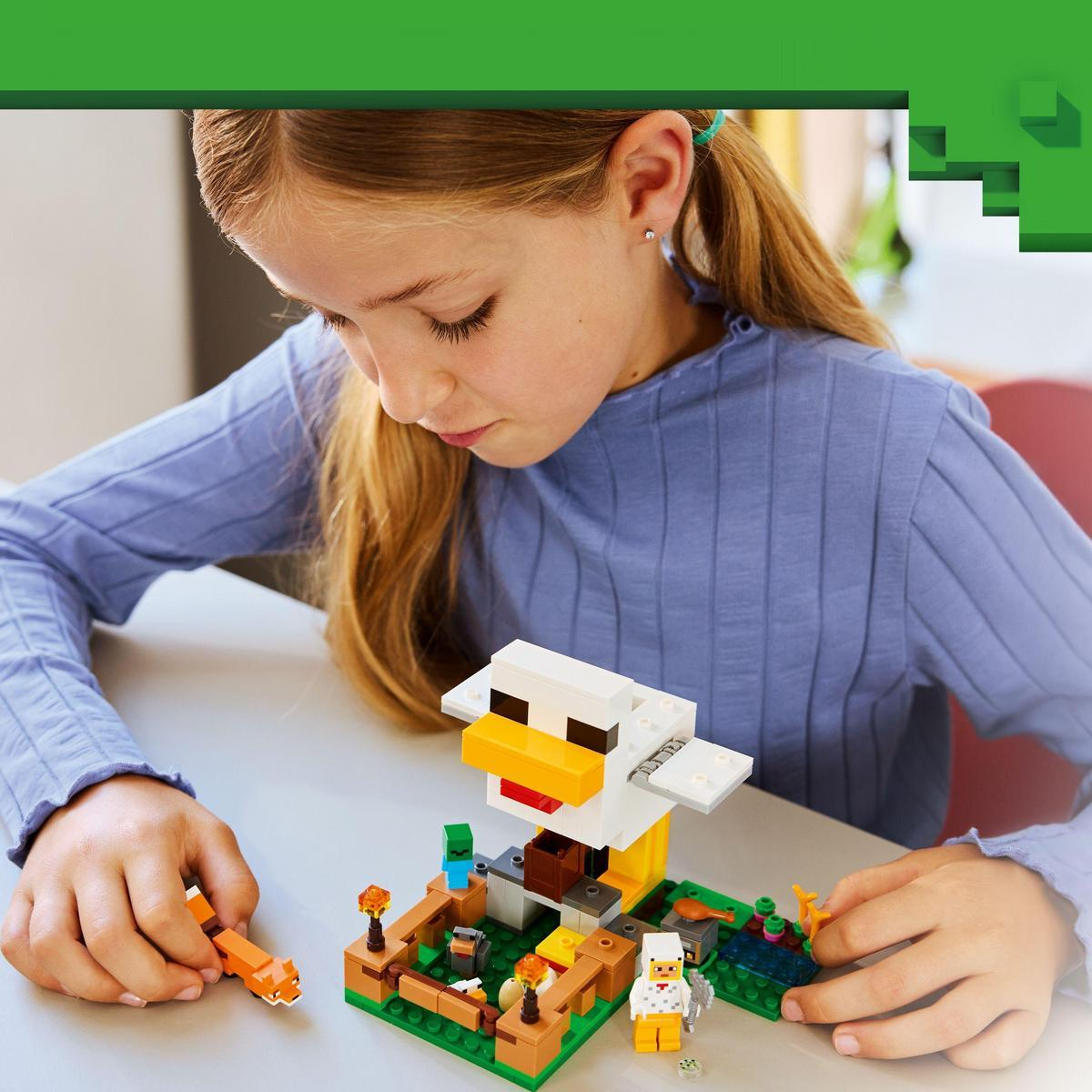 Dziewczyna patrzy na zestaw Lego Minecraft. Zestaw zawiera kurczaka, minifigurki i elementy farmy na stole.