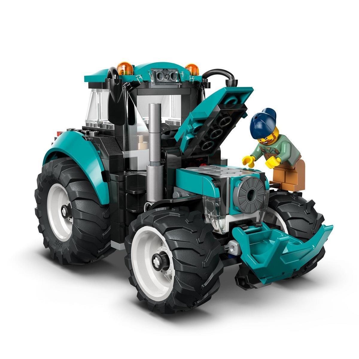 Teal i czarny traktor Lego z minifigurką sprawdzającą silnik. Traktor ma duże koła i pomarańczowe światła.