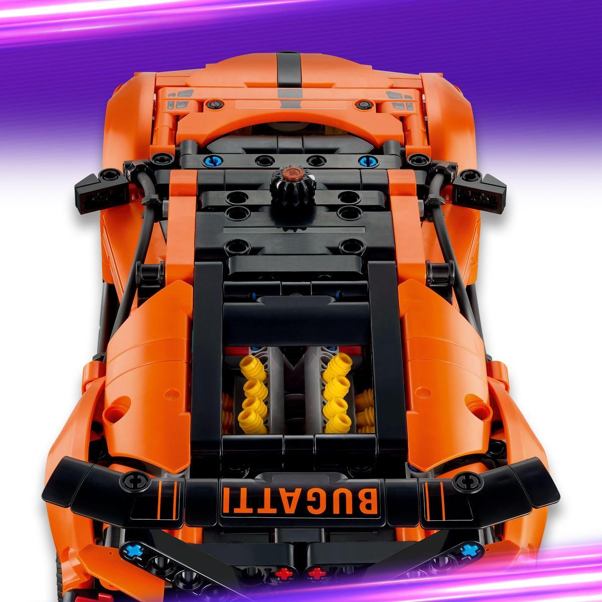 Pomarańczowy model samochodu Lego Bugatti pokazany jest z góry. Ma czarne podwozie i widoczny jest napis "BUGATTI".