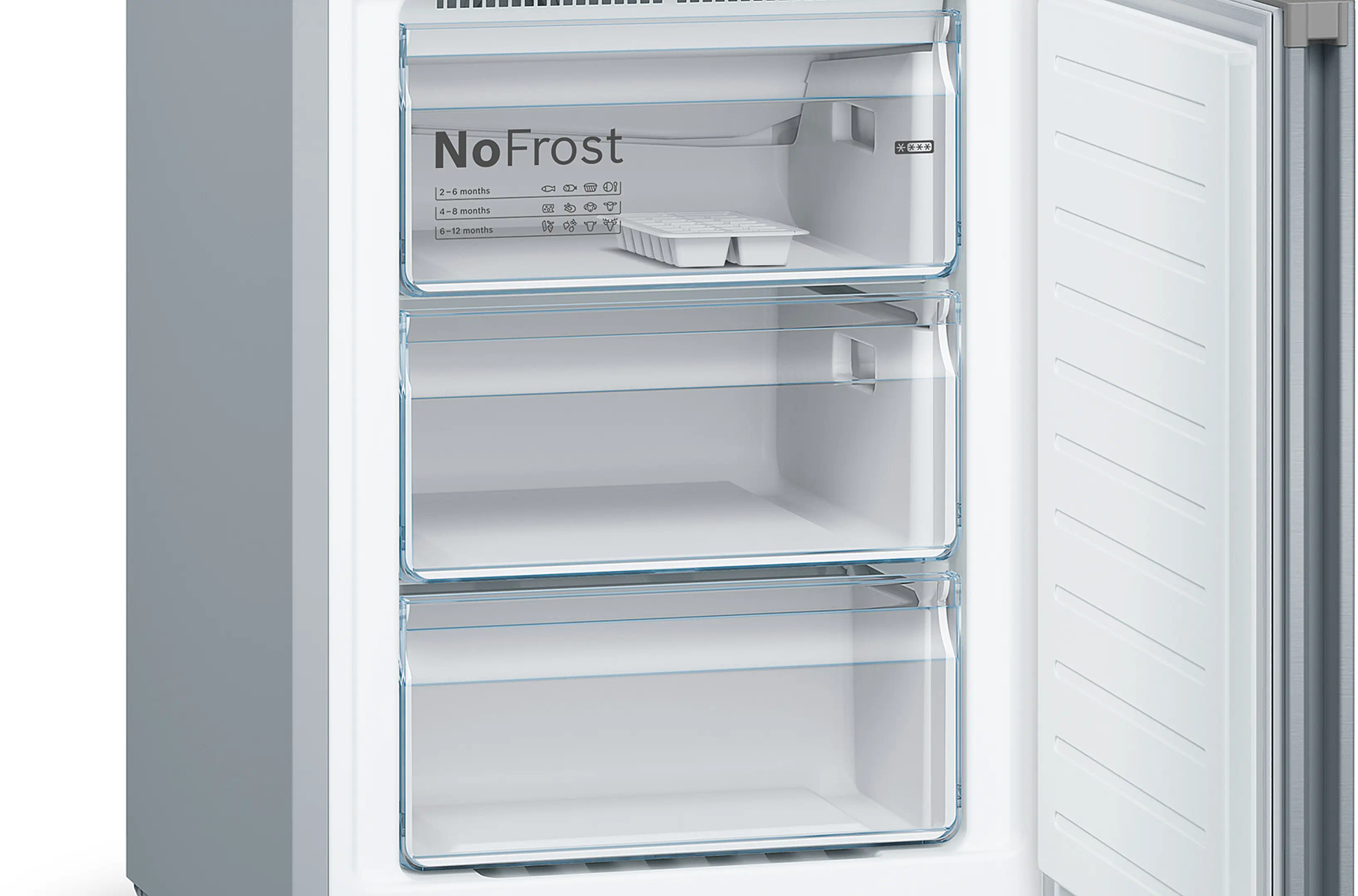 Freezer aperto con tre cassetti trasparenti. Il cassetto superiore ha un vassoio per cubetti di ghiaccio. Etichetta NoFrost visibile.