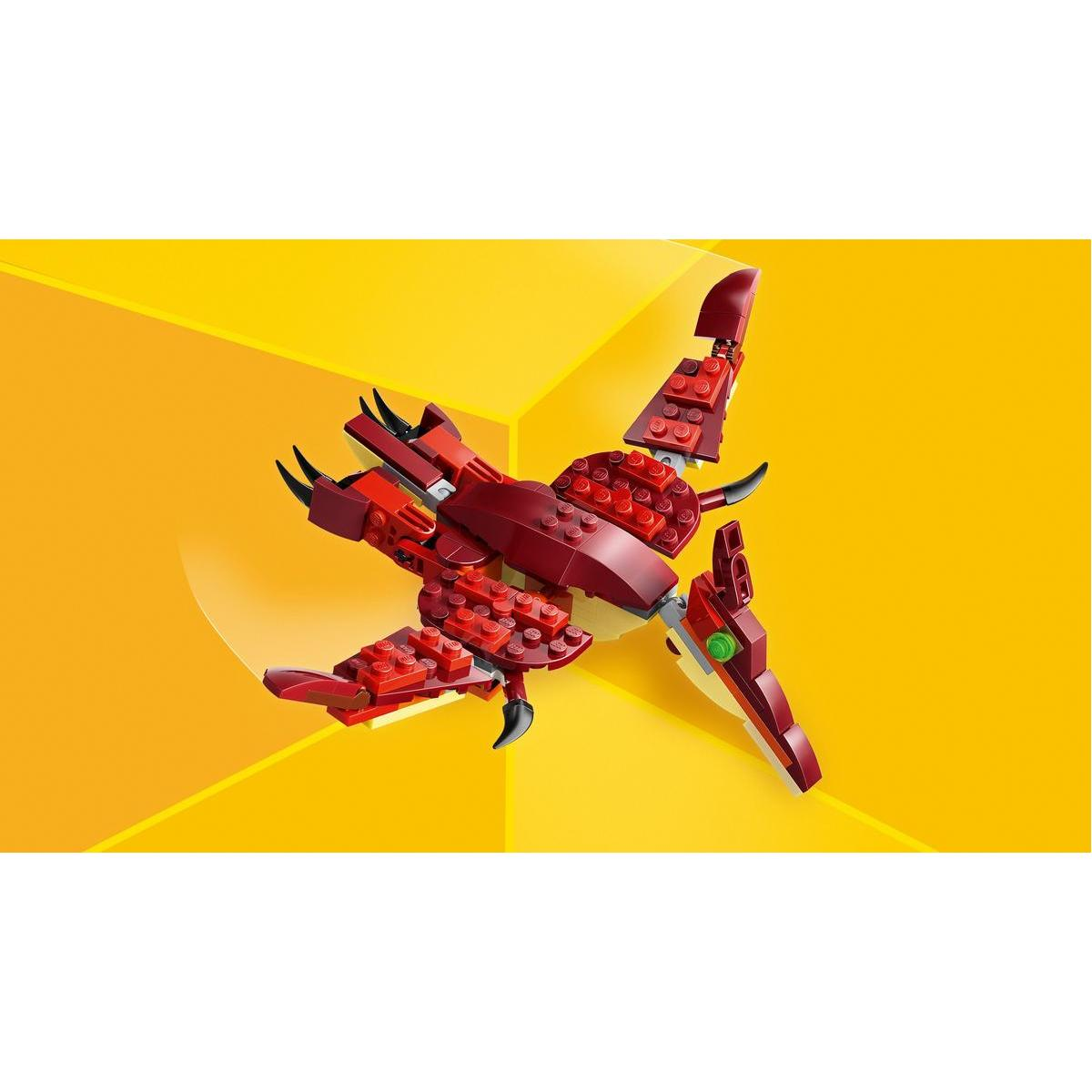 Czerwony smok Lego z czarnymi rogami i skrzydłami na żółtym geometrycznym tle.