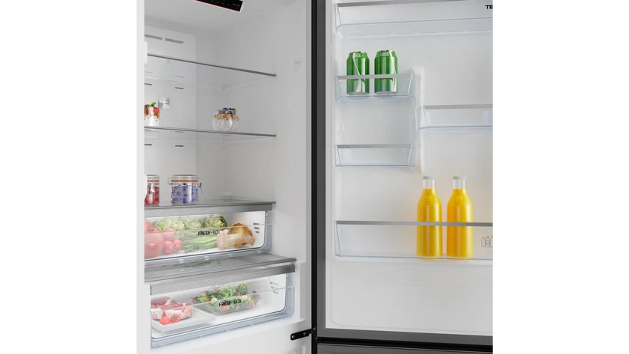 Refrigerador abierto lleno de comida. Incluye verduras, botellas de jugo, latas y frascos. Se ven estantes y cajones transparentes.
