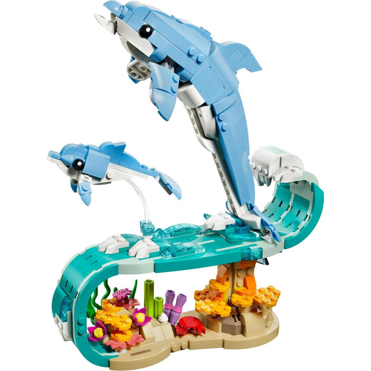 Zestaw Lego przedstawia dwa niebieskie delfiny wyskakujące z oceanu. Zestaw zawiera korale i kraba na piaszczystej podstawie.