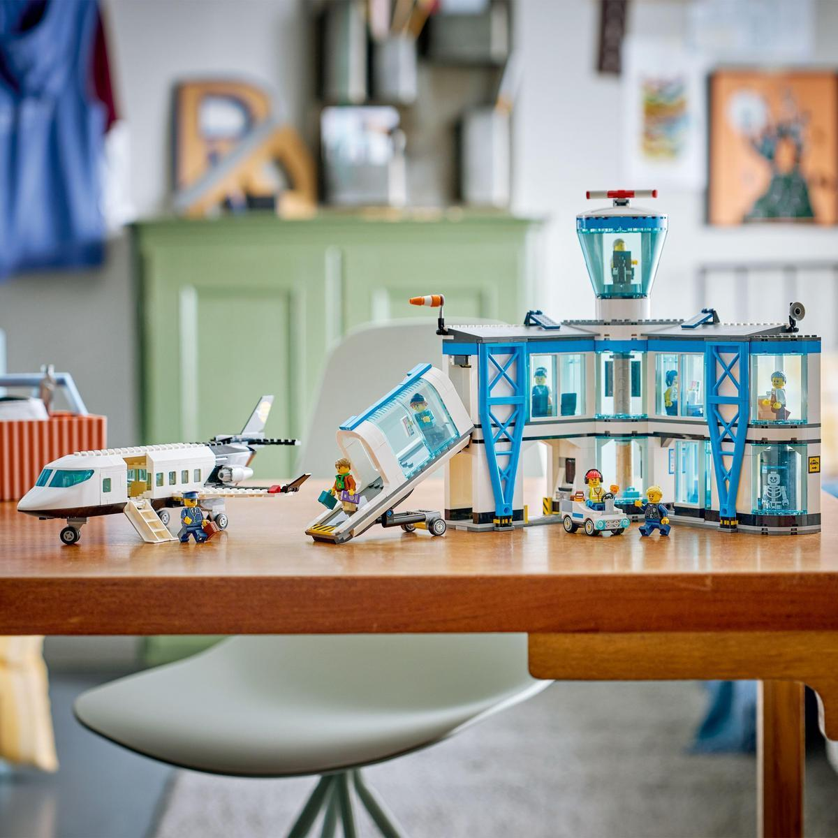 Scena lotniska z klocków Lego z samolotem, wieżą kontrolną i ludźmi. Rampa wejściowa połączona z lotniskiem. Figurki stoją dookoła.