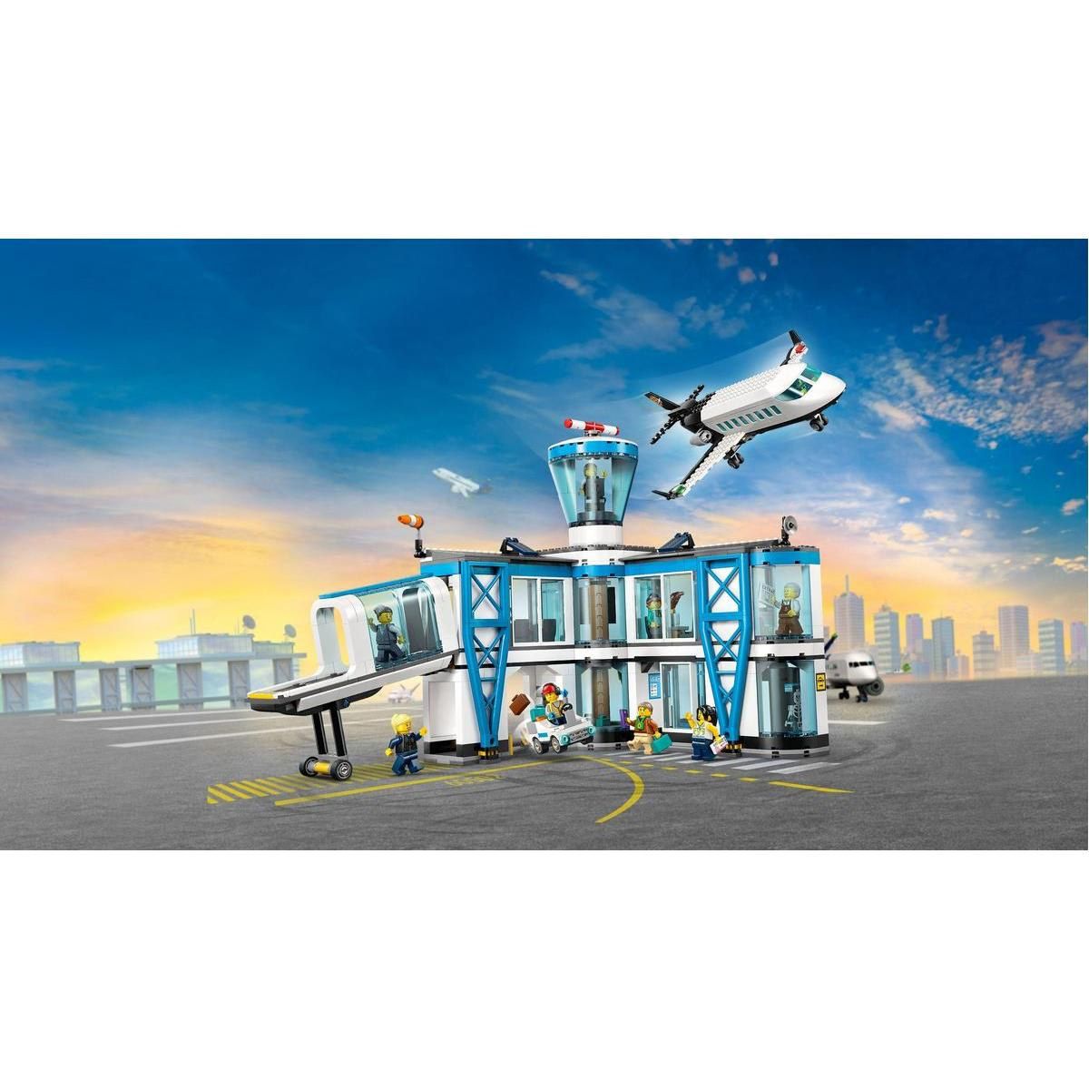 Scena lotniska Lego z startującym samolotem pasażerskim. Ludzie i pojazdy w pobliżu terminalu. Czyste niebo o zachodzie słońca.