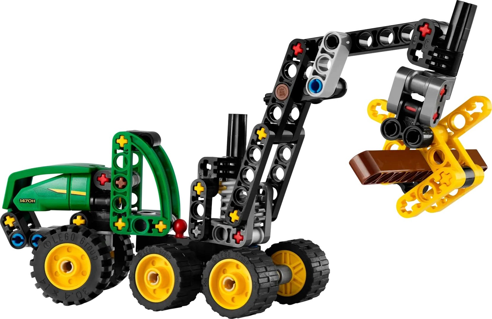 Zielony i czarny traktor Lego z żółtym chwytakiem trzymającym brązowy klocek na białym tle.