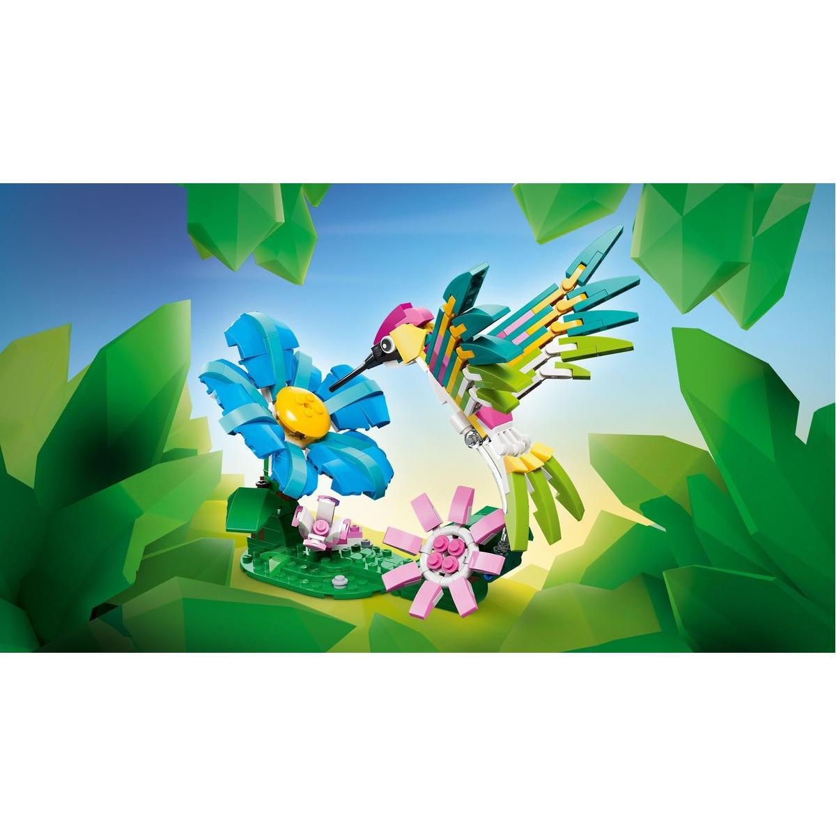 Kolorowy koliber Lego unosi się w pobliżu niebieskiego i różowego kwiatu. Zielone liście i kryształowe kształty tworzą tło.