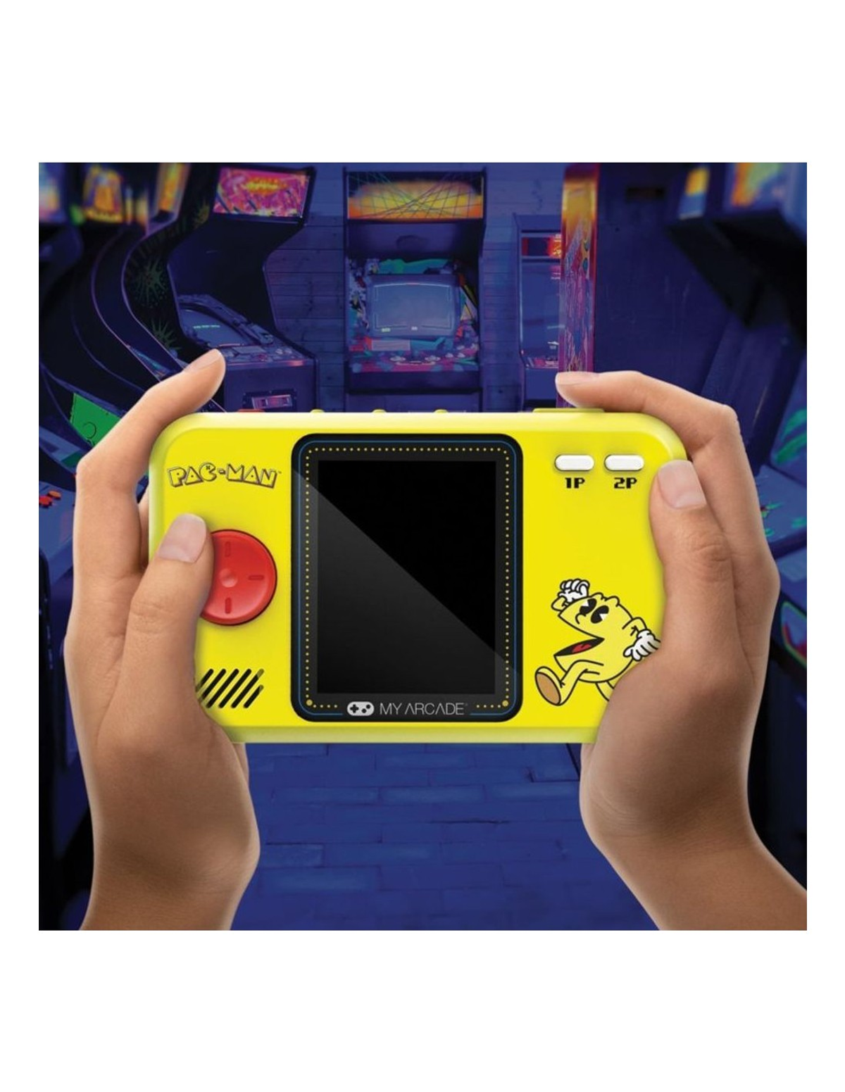 Manos sosteniendo una consola de juegos portátil Pac-Man amarilla. Fondo de arcade visible. Personaje y logotipo de Pac-Man presentes. Botones para 1P y 2P.