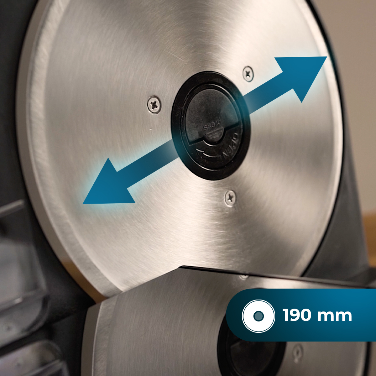 Zbliżenie srebrnej części maszyny ze strzałkami w przeciwnych kierunkach. Etykieta wskazuje 190 mm.