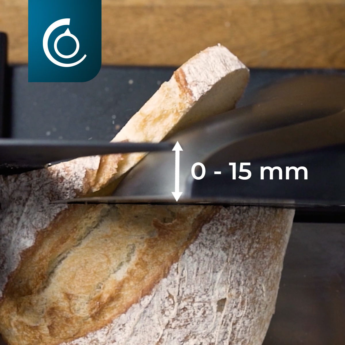 Bochenek chleba jest krojony przez maszynę. Plaster jest oddzielony. Tekst wskazuje regulowaną grubość plastra od 0 do 15 mm.