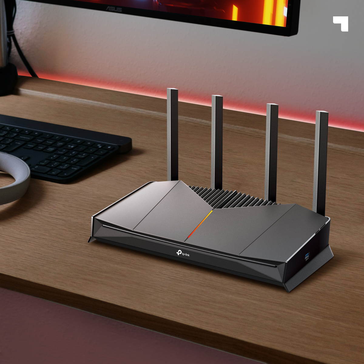 Ein moderner schwarzer TP-Link-Router steht auf einem Holzschreibtisch. Eine Tastatur, ein Monitor und Kopfhörer sind ebenfalls zu sehen.