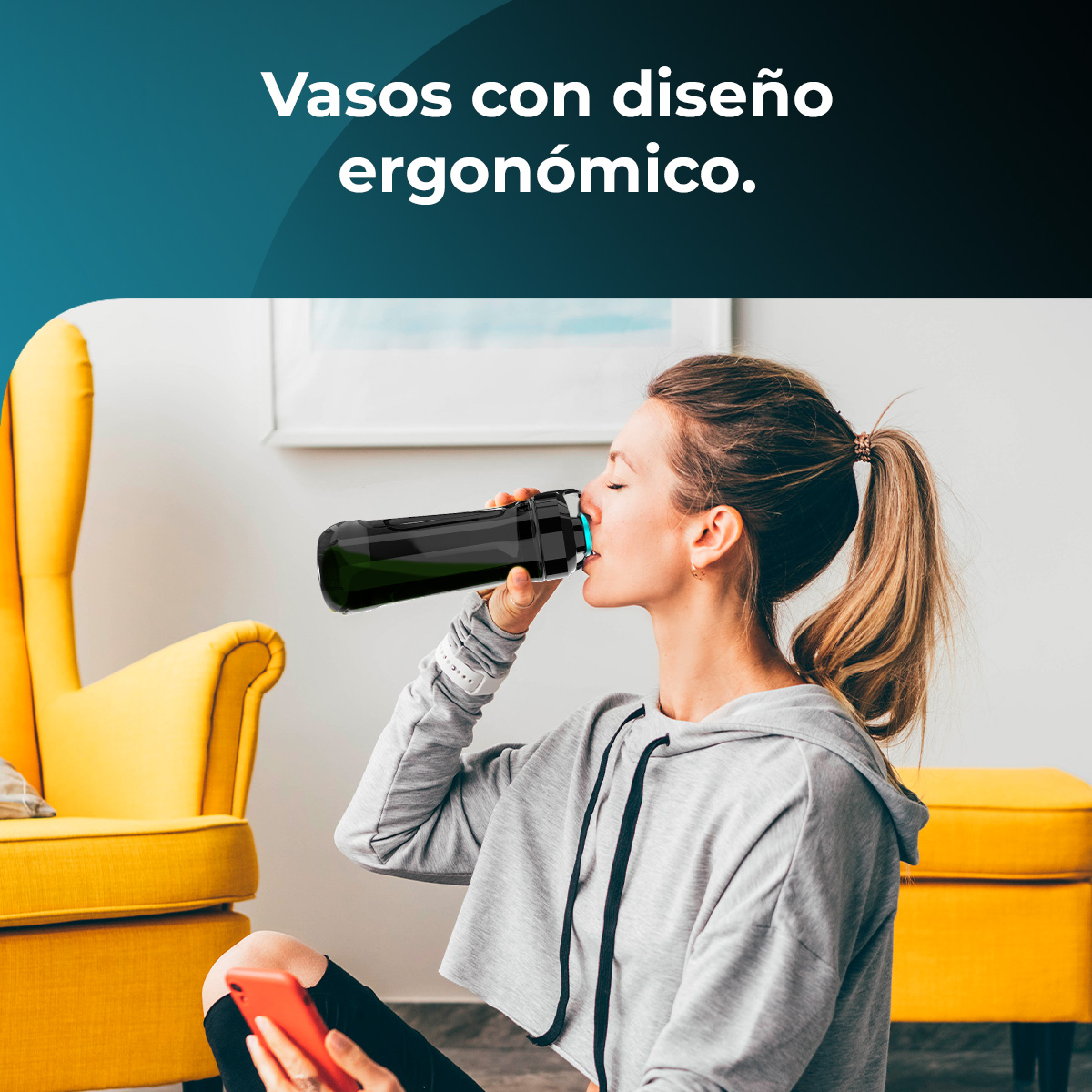 Una donna beve da una borraccia nera. È seduta vicino a mobili gialli. Un telefono rosso è appoggiato sulle sue ginocchia. Lo sfondo è bianco.