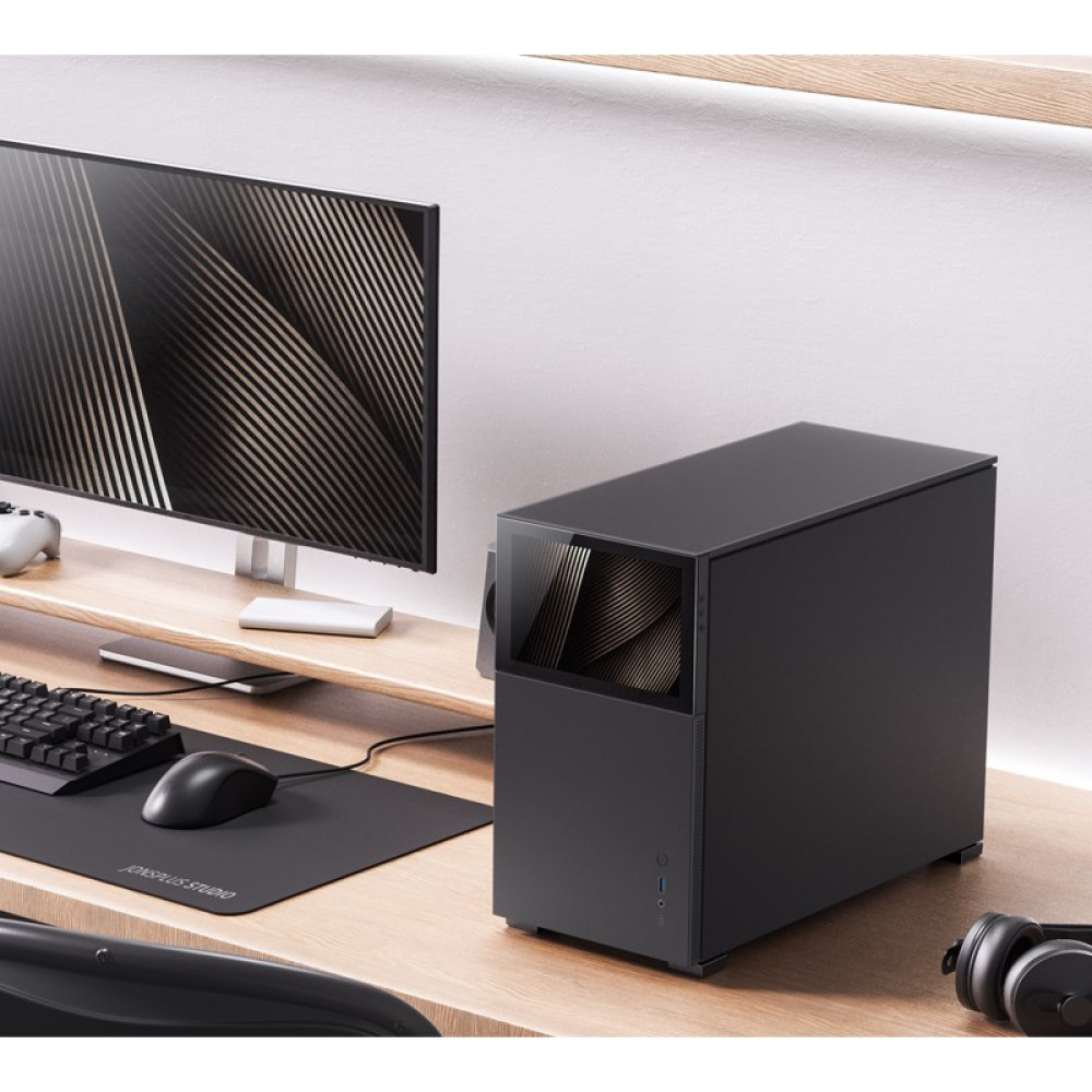 A modern desktop setup with a black computer tower, monitor, keyboard, mouse, and headphones on a wooden desk.