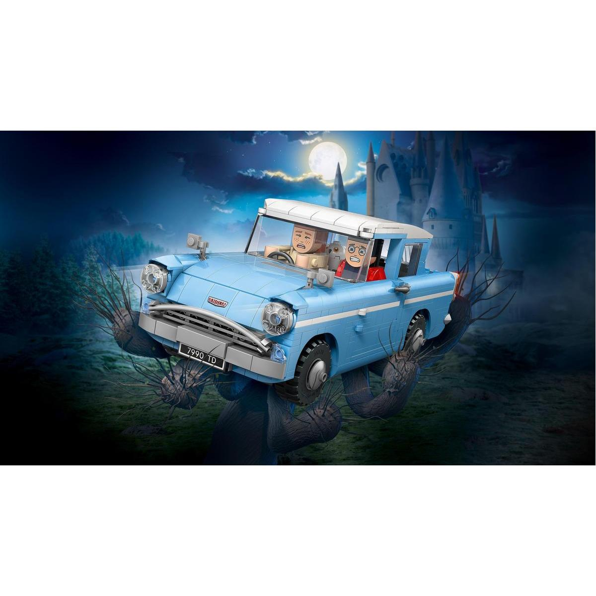 Niebieski samochód Lego z dwiema postaciami w środku. Zamek Hogwart i pełnia księżyca w tle. Gałęzie owijają samochód.