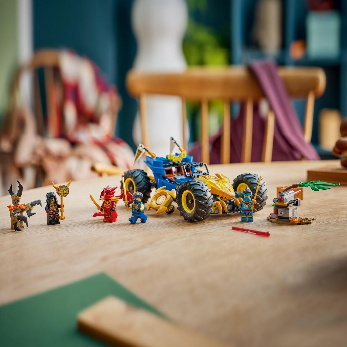 Niebiesko-żółty samochód Lego otoczony figurkami Lego na drewnianym stole. Obecny jest również czerwony miecz i zielona roślina.