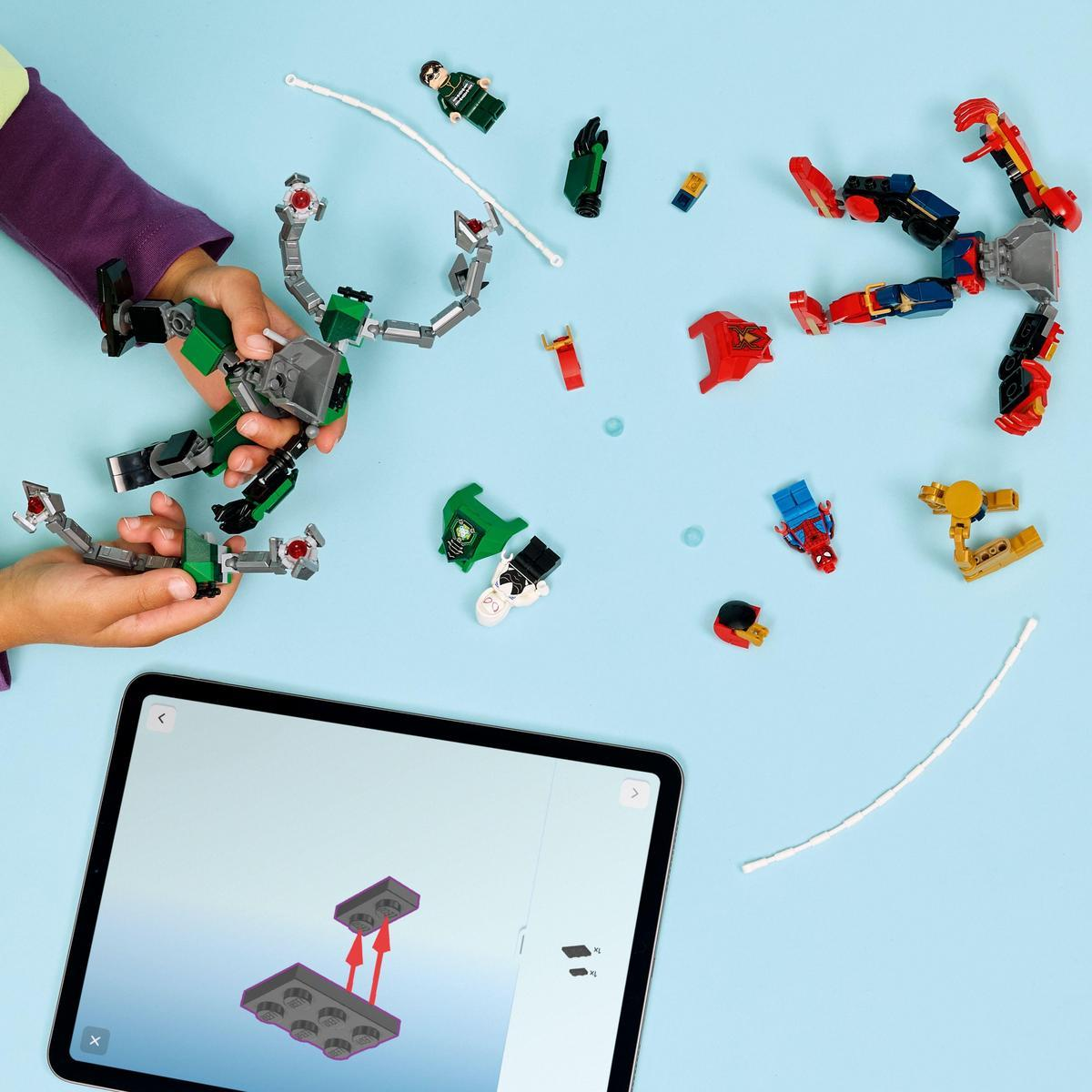 Dziecko buduje robota Lego na niebieskiej powierzchni. Tablet wyświetla instrukcje. Figurki i części Lego rozrzucone.